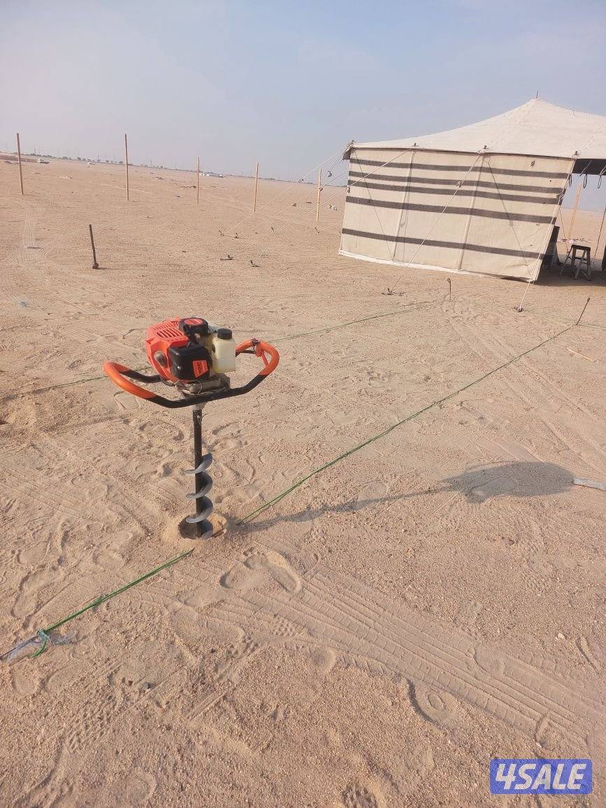 حفارة ركايز مع عامل تركيب اسوار المخيمات1