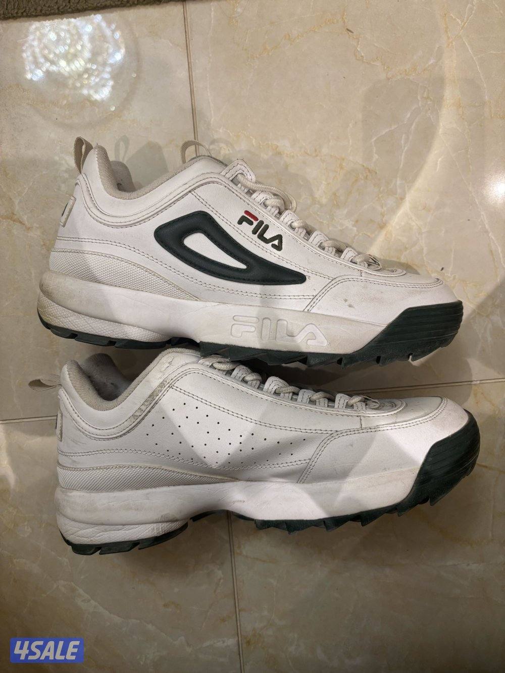 white Fila Disruptor I| sneaker with a navy blue and red logo0